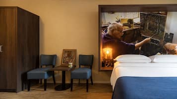 Ein Hotelzimmer mit einem Bett, zwei Stühlen, einem Tisch und einem Kleiderschrank.