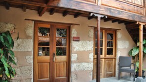 A rustic building with a wooden door, stone walls, and a balcony with wooden beams. - Hotel Rural El Mondalón (Las Palmas de Gran Canaria)