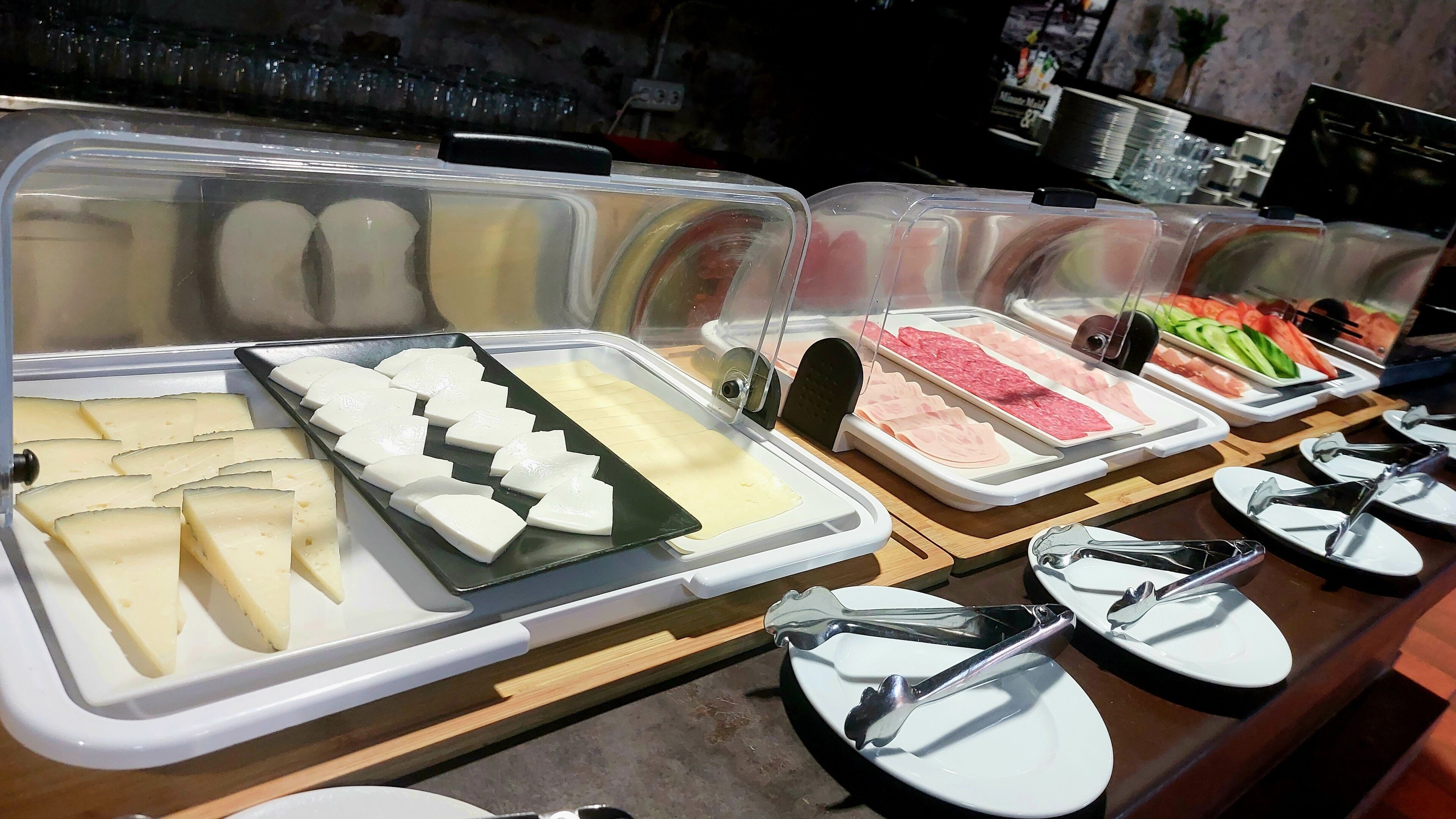 A buffet with various food items in clear containers.