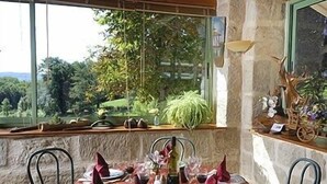 A dining table set for four with a menu, wine glasses, and a vase of flowers. - Le Domaine de Renaudet (Saint-Pantaleon-de-Larche)