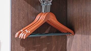 Een houten deur met een metalen haak aan waar meerdere oranje ophanghaaks hangen.