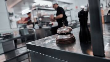 A kitchen counter with a pepper grinder and a salt shaker.