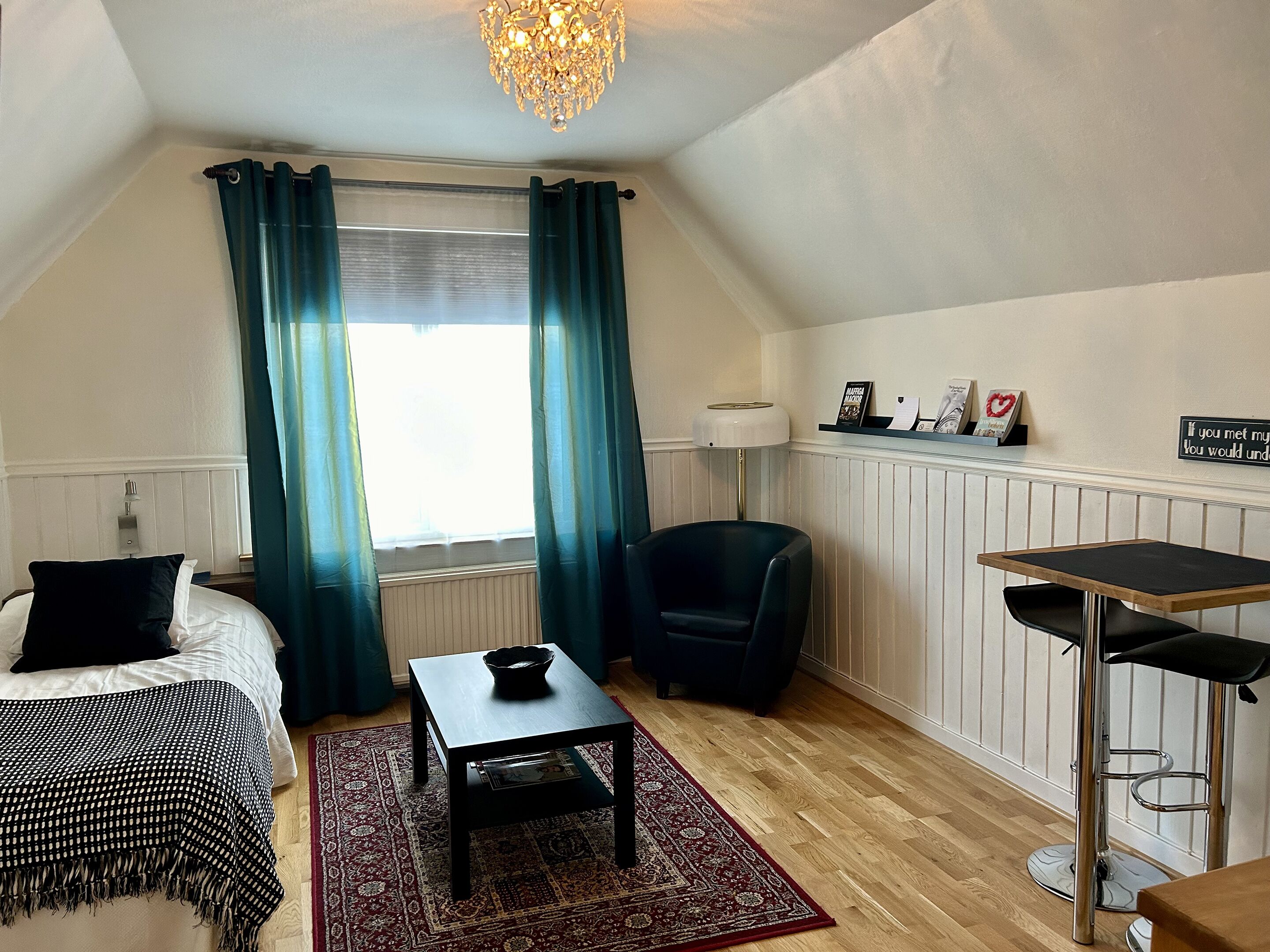 Una habitación acogedora con una cama, una mesita, una silla y un escritorio.