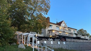Un bâtiment doté d’un mur en pierre, d’un escalier en bois et d’une enseigne indiquant « Skulptura Bauskottell ».