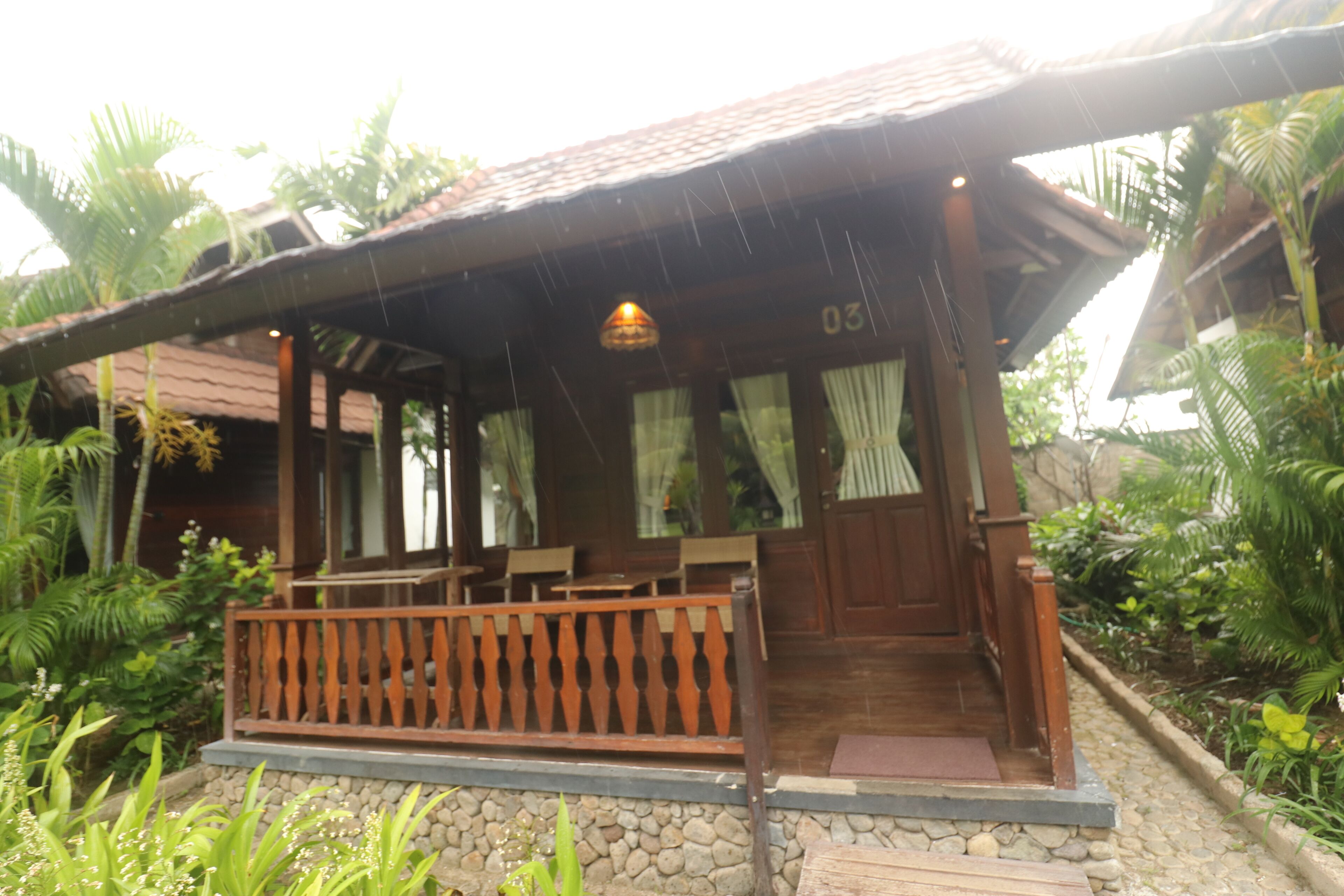 A wooden building with a porch, stone steps, and a wooden railing.