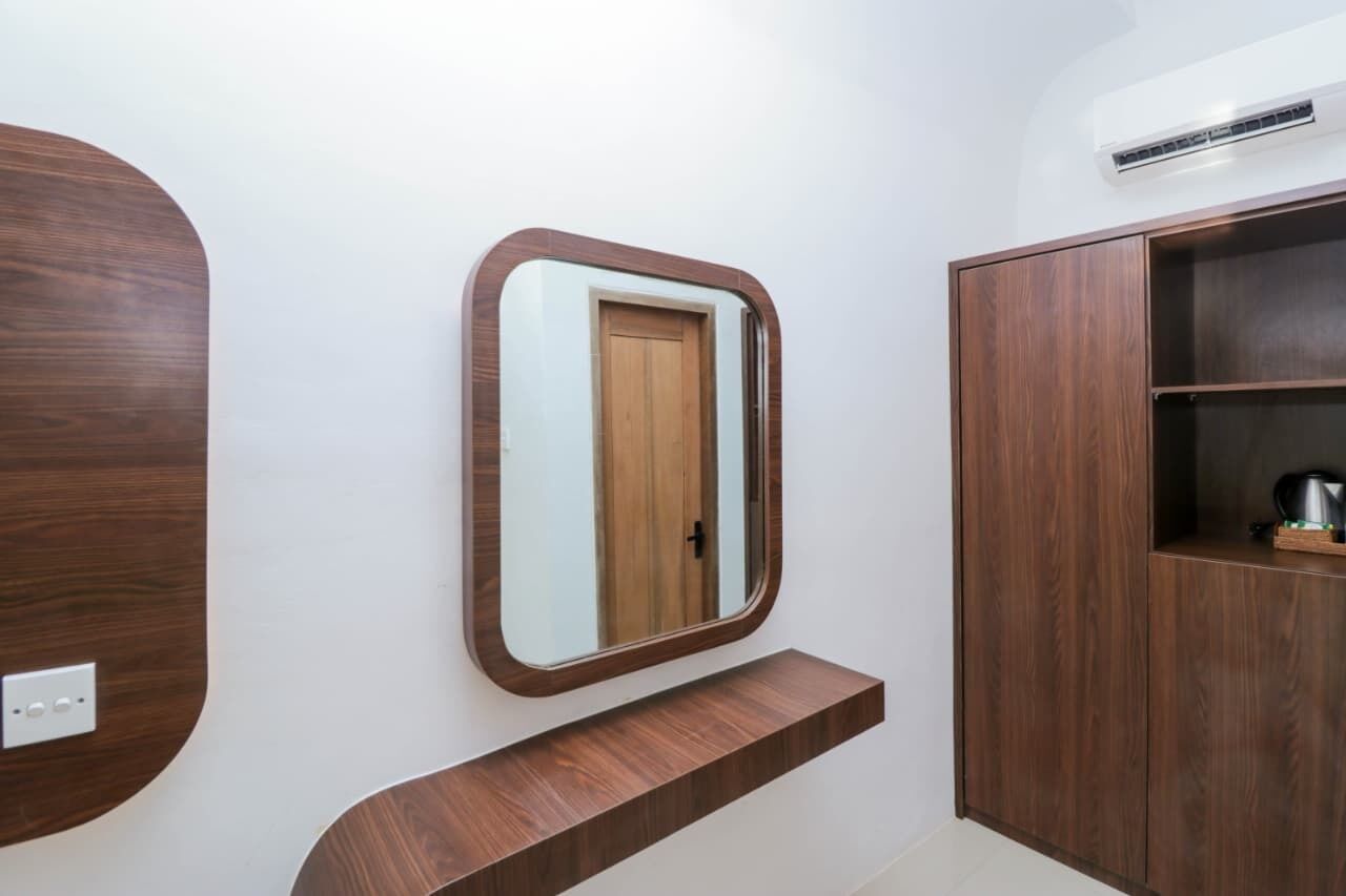 A modern bathroom with a wooden vanity, a mirror, and a cabinet.