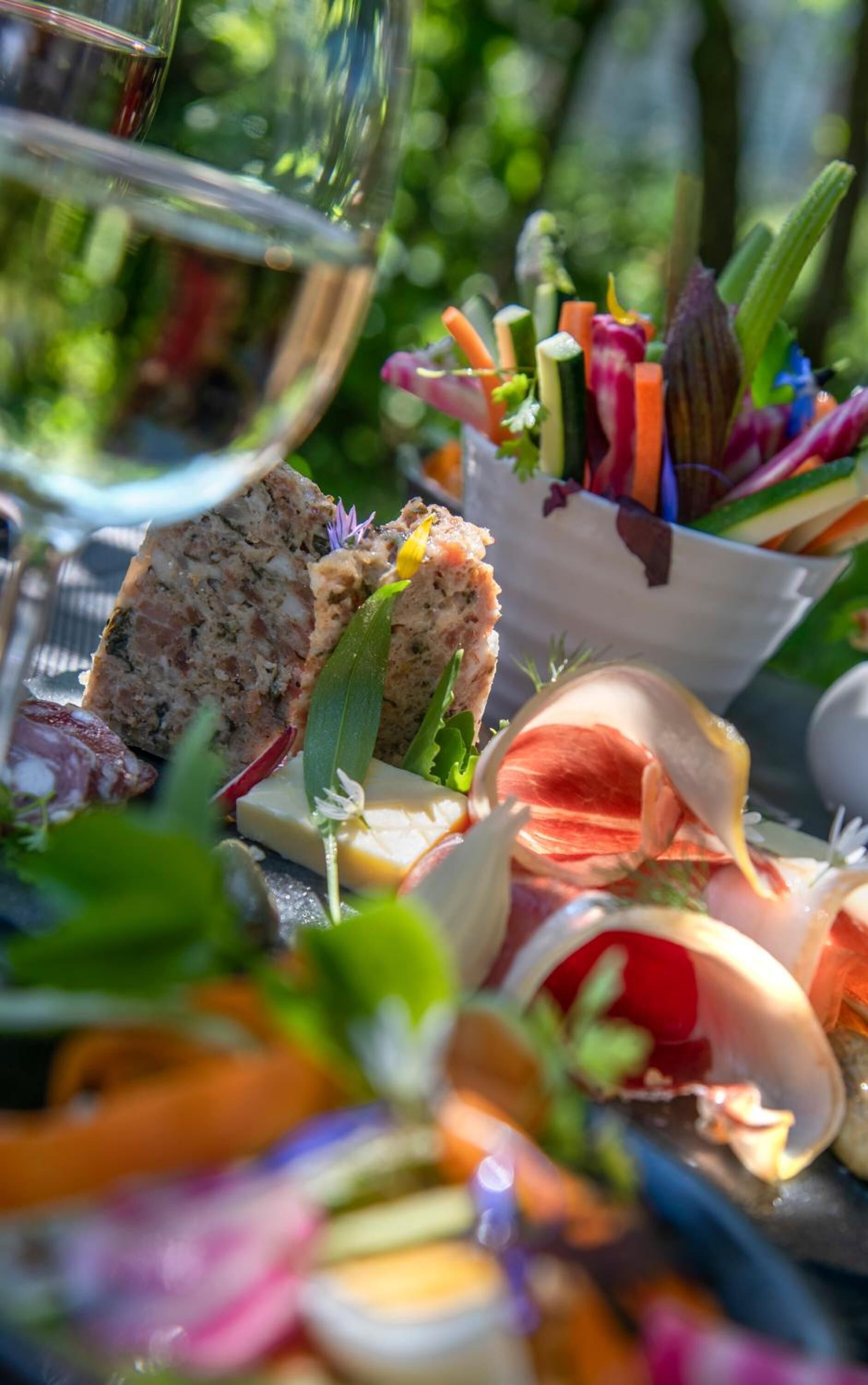 Diverse etenswaren, zoals brood, kaas en groenten, wat doet denken aan een picknick of diner in de openlucht.