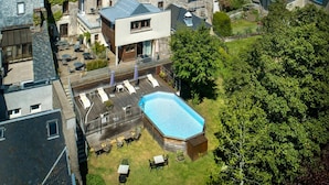A residential area with stone buildings, a swimming pool, and outdoor seating. - Gilles Moreau (Laguiole)