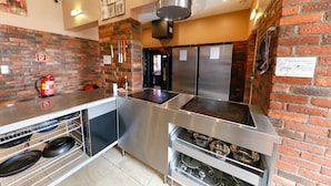 A kitchen with a brick wall, stainless steel appliances, and a fire extinguisher. - Do Step Inn (Vienna)