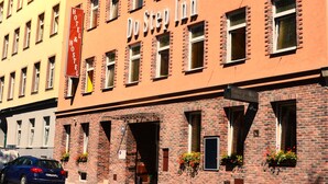 A hotel named "Do Step Inn" with a brick facade, multiple windows, and a visible entrance. - Do Step Inn (Vienna)