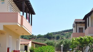 A residential area with two-story houses, a garden with roses, and a clear sky.