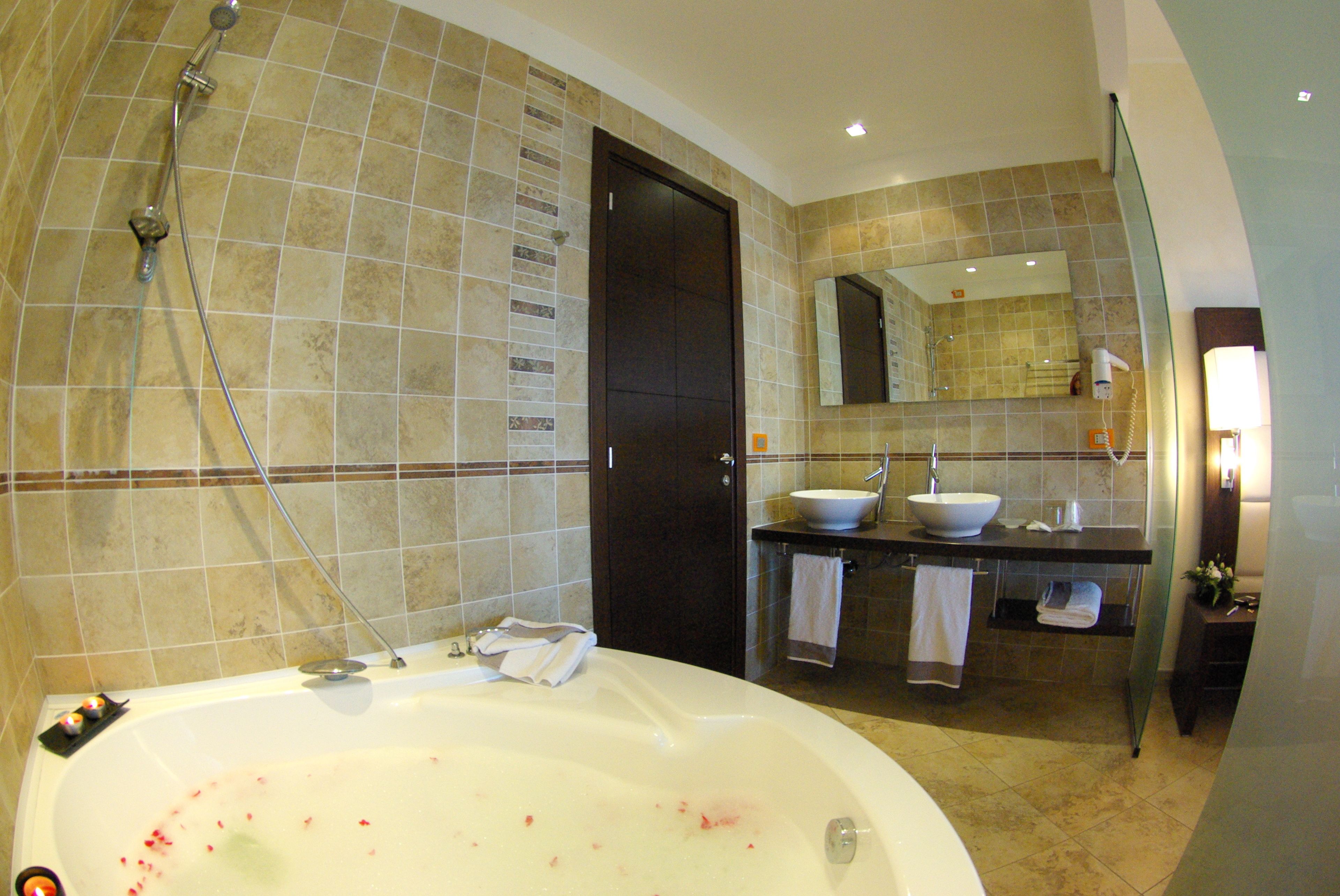 Un bagno con una vasca, un lavandino, uno specchio e una doccia.