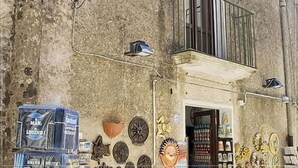 A building with a stone facade, a balcony, and various decorative items on the wall. - B&B Erice Antico Borgo (Erice)