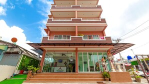 Un edificio de varios pisos con entrada de vidrio y un letrero que dice "Phu Thai House 3".
