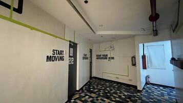 A hallway with motivational wall art, a patterned floor, and a door with a fire extinguisher.