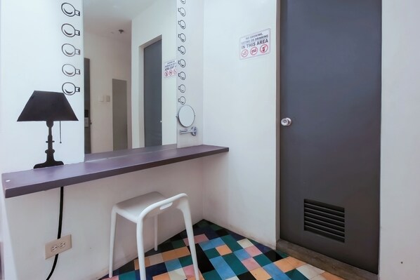 Une salle de bain avec un miroir, un lavabo, une chaise et une porte.