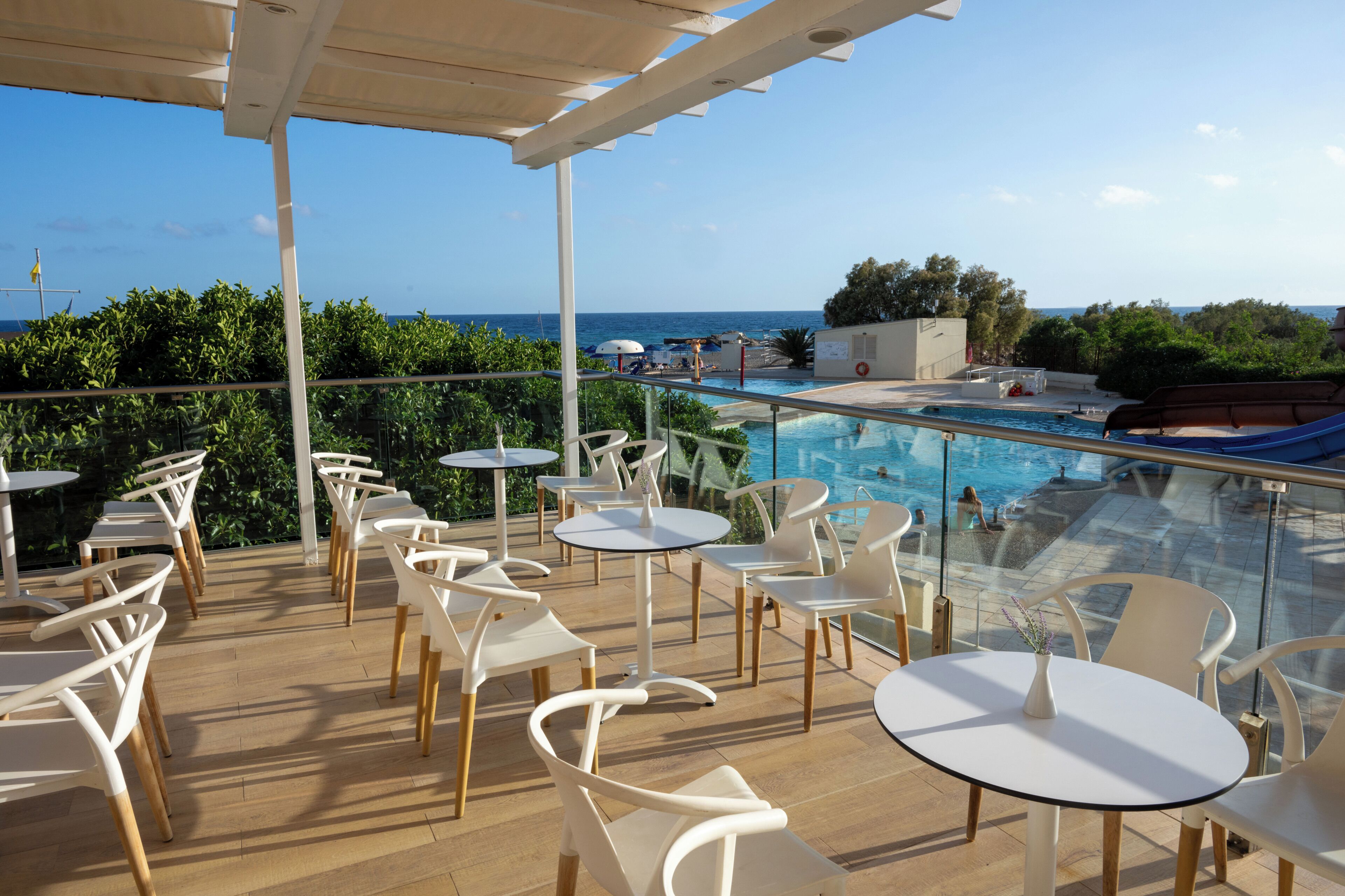 Une terrasse sur le toit avec des sièges extérieurs, une piscine et une vue sur la mer.