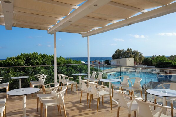 Une terrasse sur le toit avec des sièges extérieurs et une vue sur la piscine.