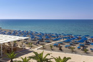 On the beach, black sand, sun loungers, beach umbrellas