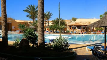 Piscine couverte, piscine extérieure, parasols de plage, chaises longues