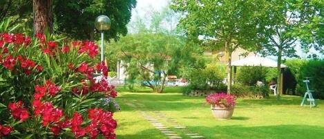 Un giardino curato con un vialetto in pietra che conduce a un edificio.