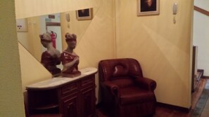 A bathroom with a vanity, a brown leather chair, and a mirror. - Pensão Residencial Flor dos Cavaleiros (Lisbon)