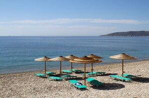På stranden, solsenger og parasoller