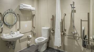 Een badkamer met een wastafel, toilet, spiegel en douche.