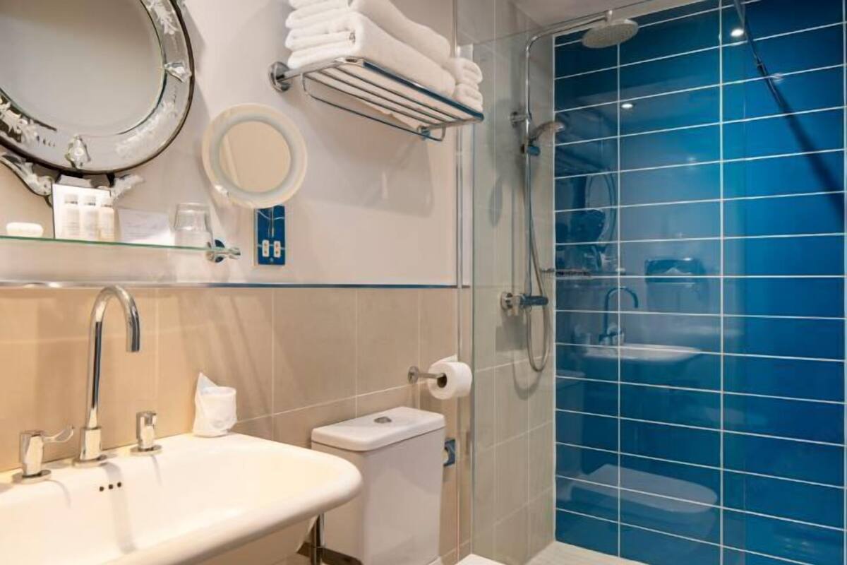 A bathroom with a sink, toilet, and shower.
