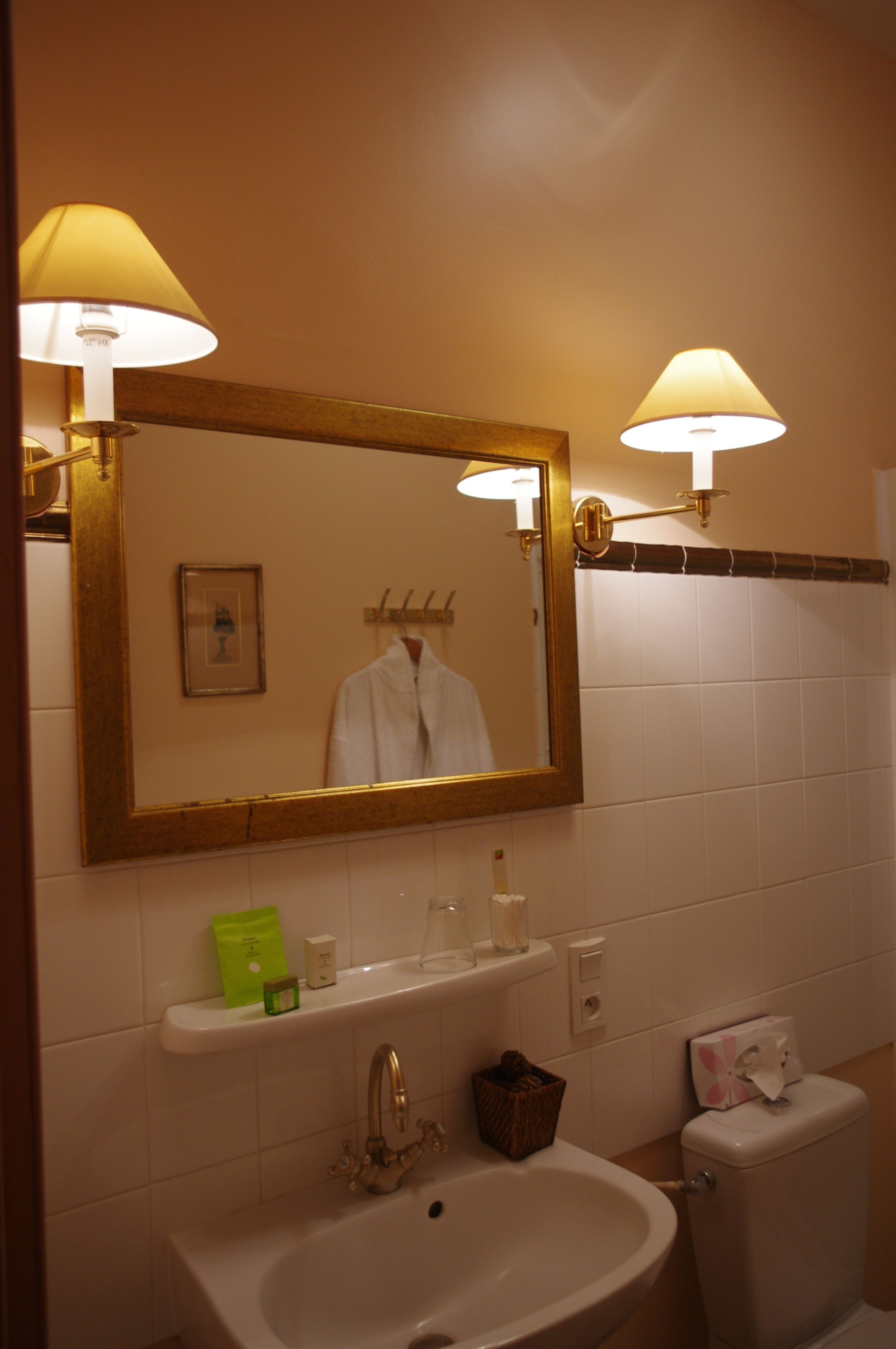 Een badkamer met een wastafel, spiegel en toilet.