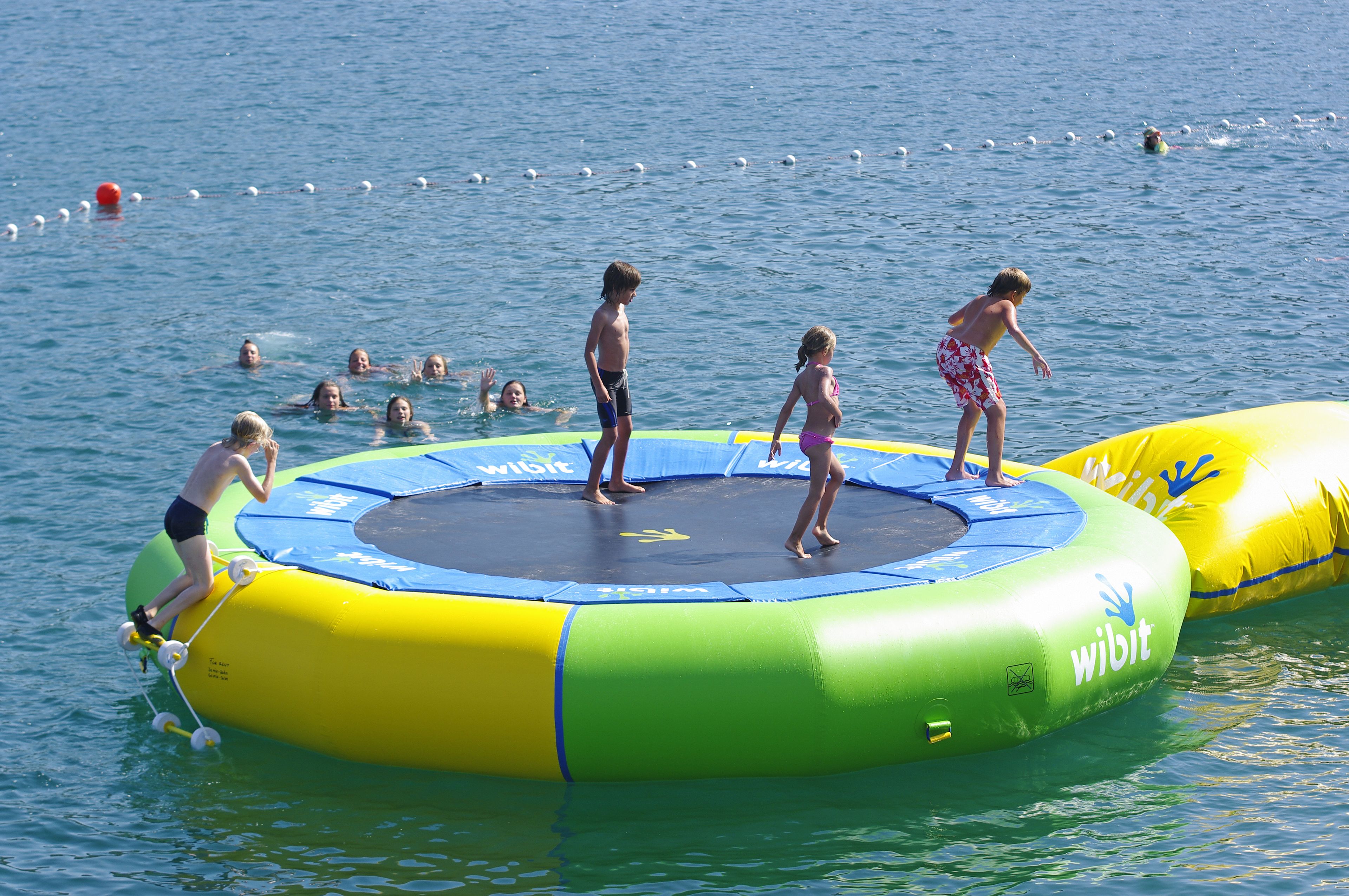 A water-based trampoline with people on it.