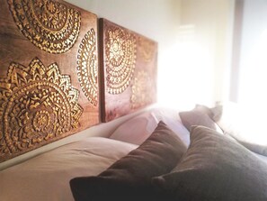 A bed with a wooden headboard featuring intricate carvings. - Hôtel l'Orée des Bois (La Breille-les-Pins)