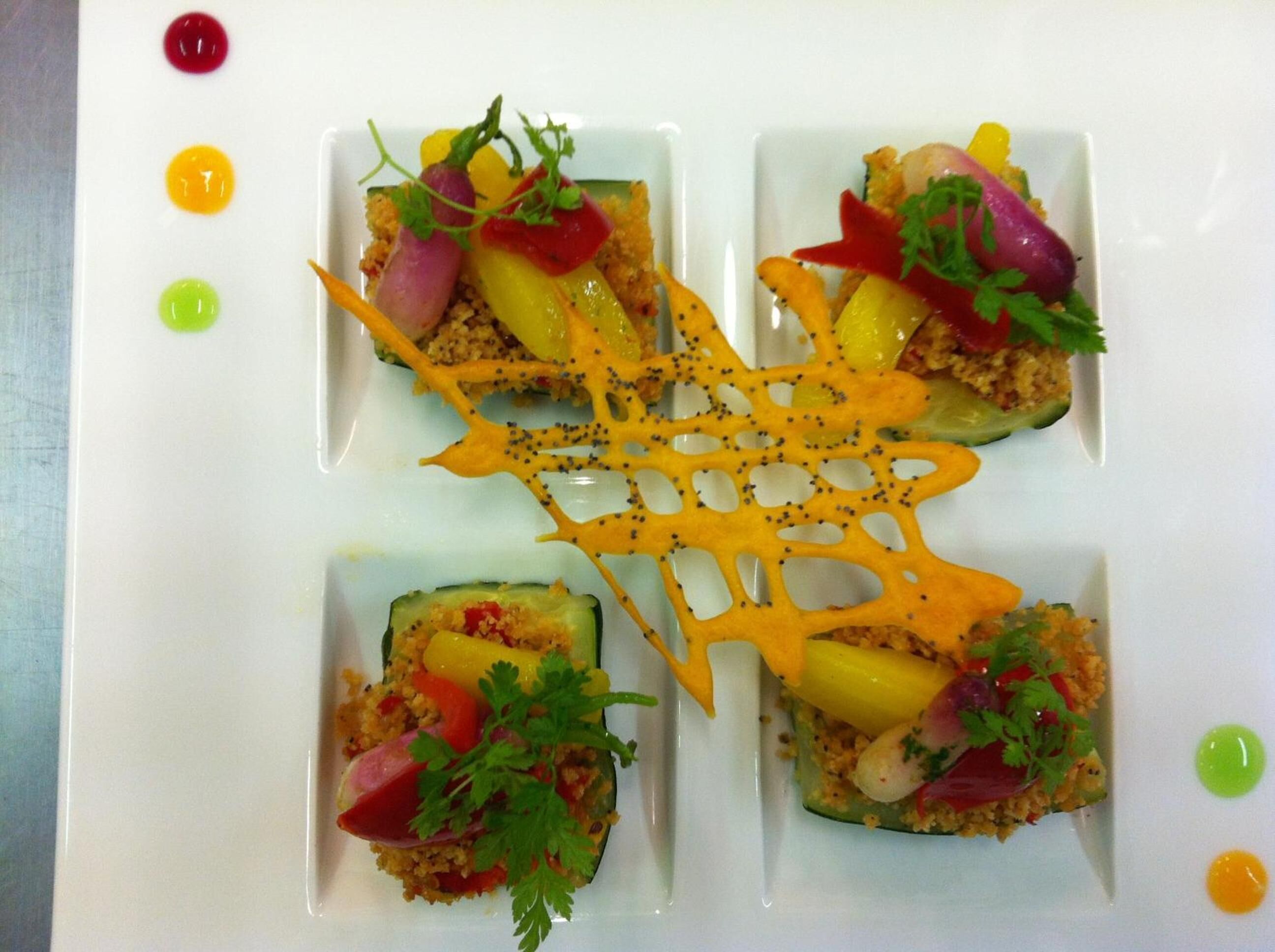 Un plat quadrat dividit en quatre porcions, cadascuna amb aliments i decorat amb julivert.