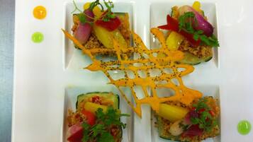 Un plat quadrat dividit en quatre porcions, cadascuna amb aliments i decorat amb julivert.