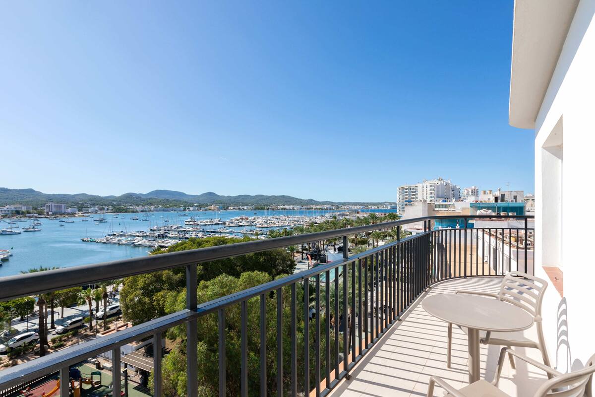 Ein Balkon mit Blick auf einen Yachthafen und die Skyline der Stadt.