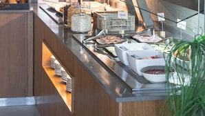 Una mesa de buffet con distintos alimentos y salsas.