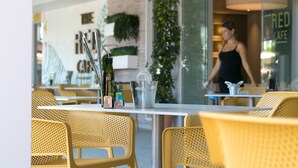 Un restaurante con sillas de mimbre amarillas y una mesa con botellas y un balde.