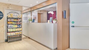 A reception area with a counter, a snack display, and a refrigerator. - B&B Hotel Milano Sant'Ambrogio (Milan)
