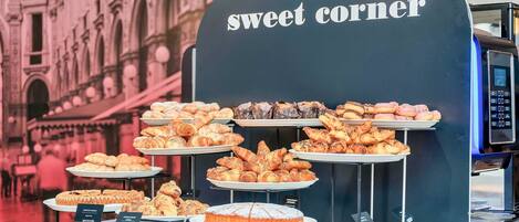 A bakery display with various pastries and a coffee machine.