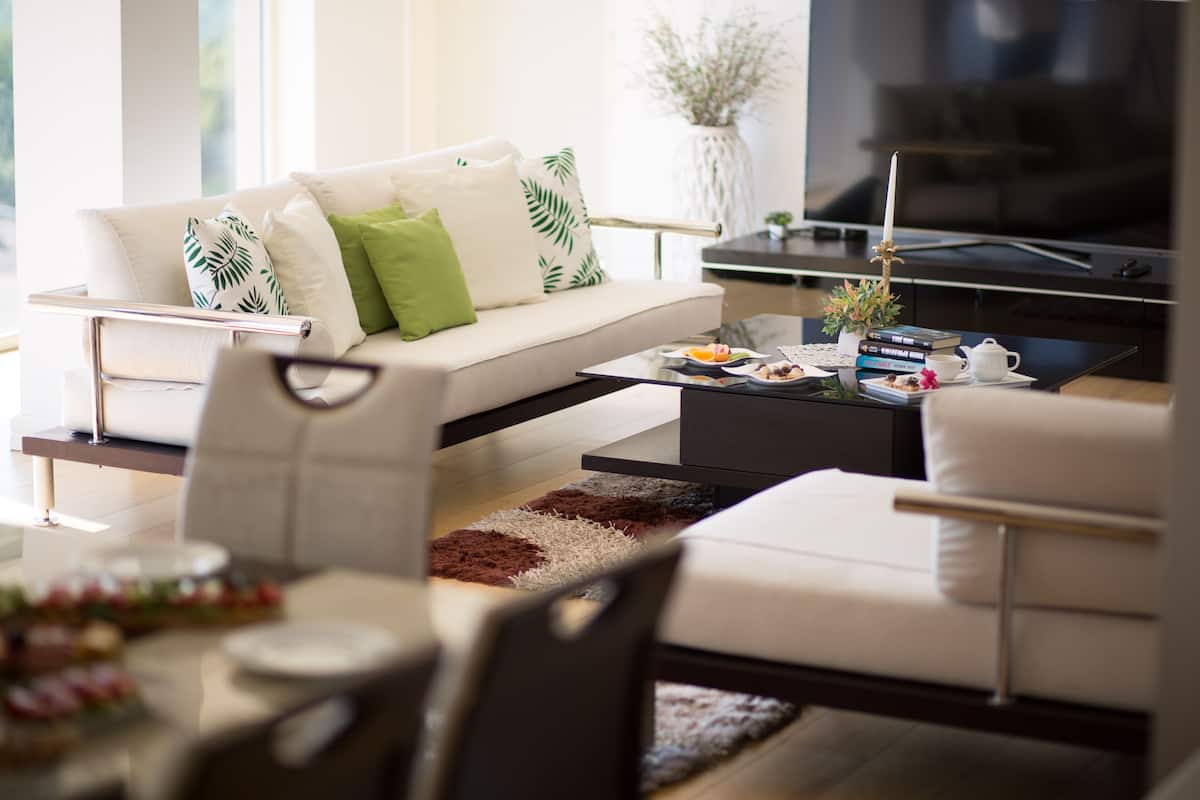 Una sala de estar moderna con sofá, mesa de centro y comedor.