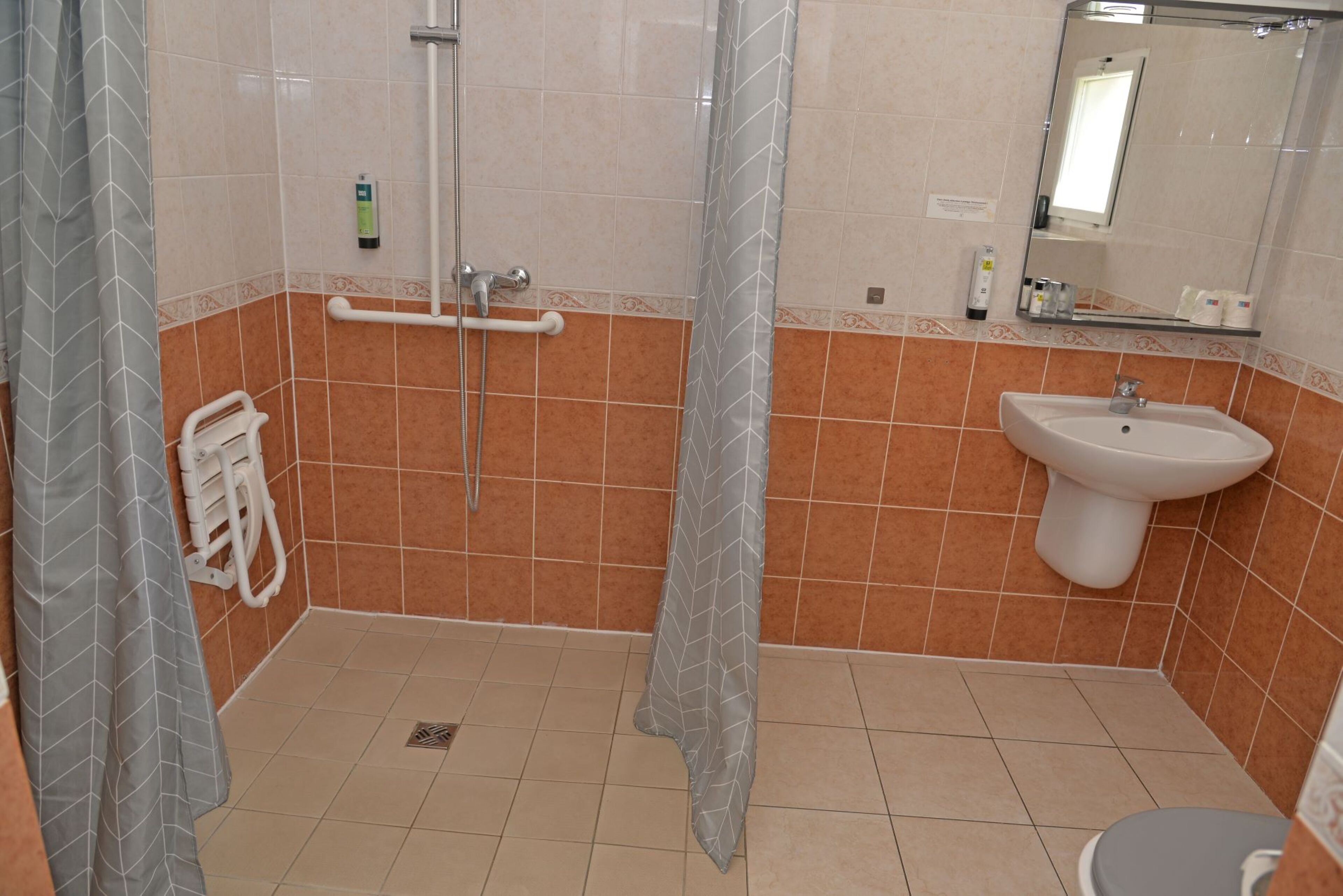 Un baño con ducha, lavabo e inodoro.
