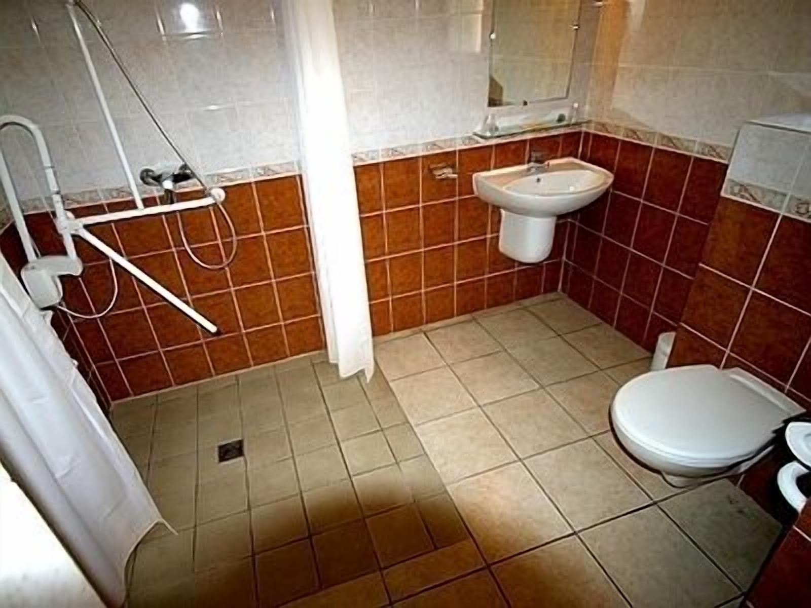 Une salle de bain avec une douche, un lavabo et des toilettes.