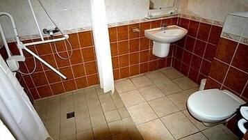 Une salle de bain avec une douche, un lavabo et des toilettes.