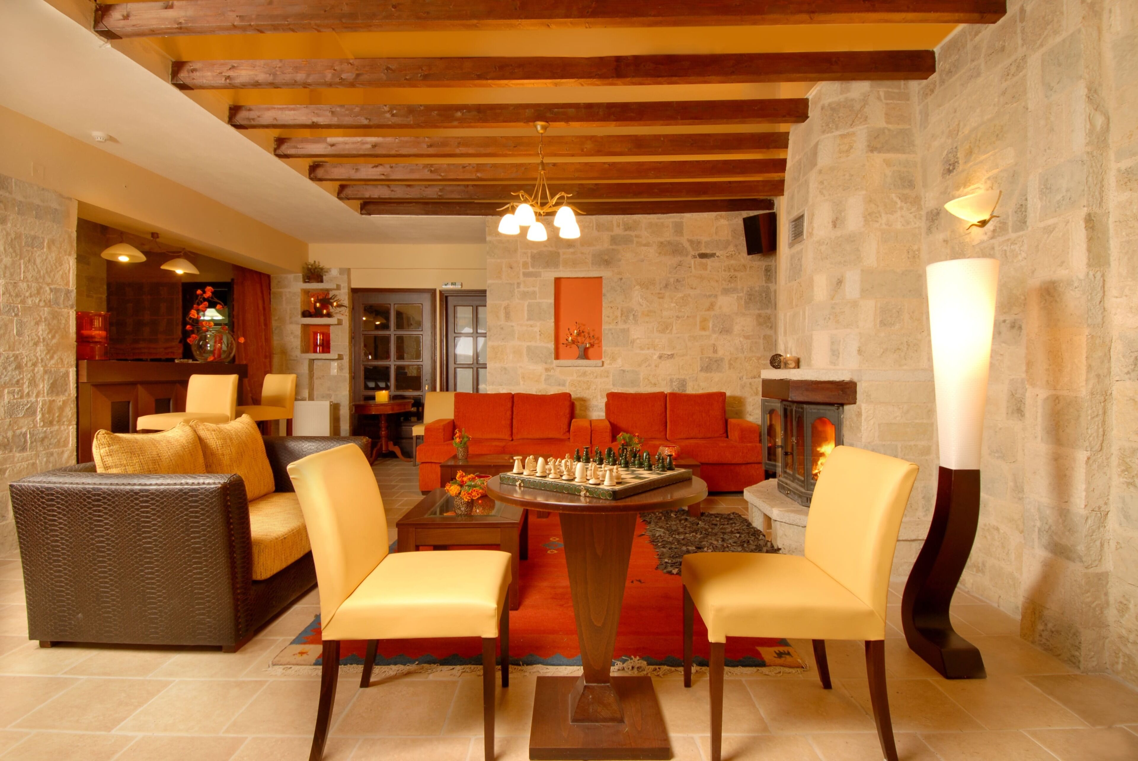 A cozy living room with a fireplace, a chessboard, and comfortable seating.