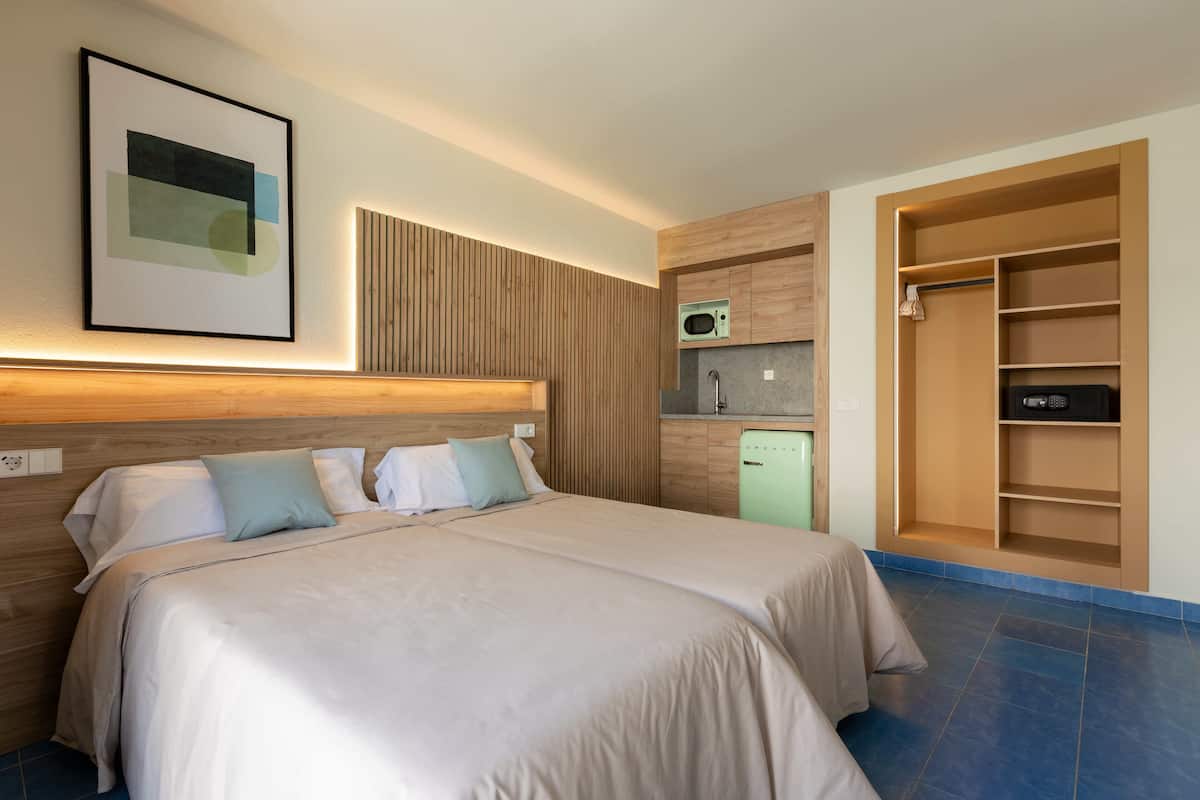 Ein Hotelzimmer mit Bett, Mikrowelle, Minikühlschrank und einem Einbauschrank.