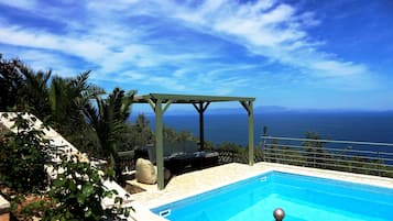 Piscine extérieure, parasols de plage, chaises longues