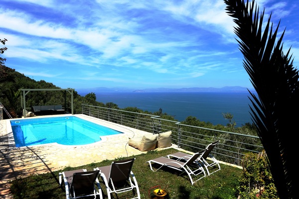 Una piscina al aire libre, sombrillas, sillones reclinables de piscina