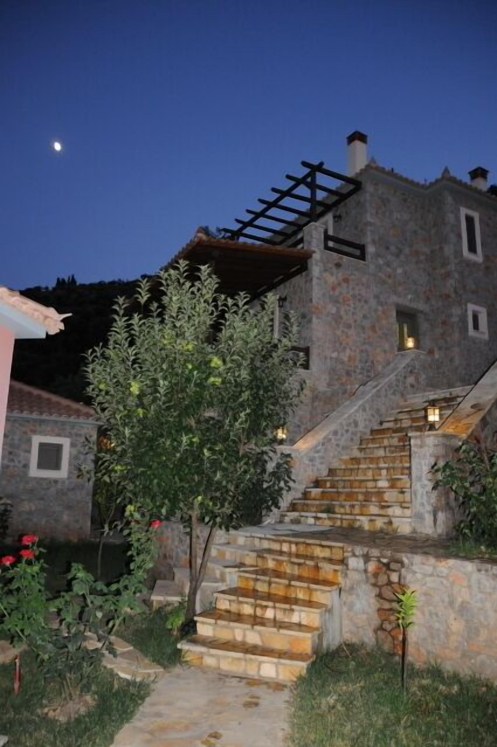 A stone building with a staircase leading to a wooden deck.