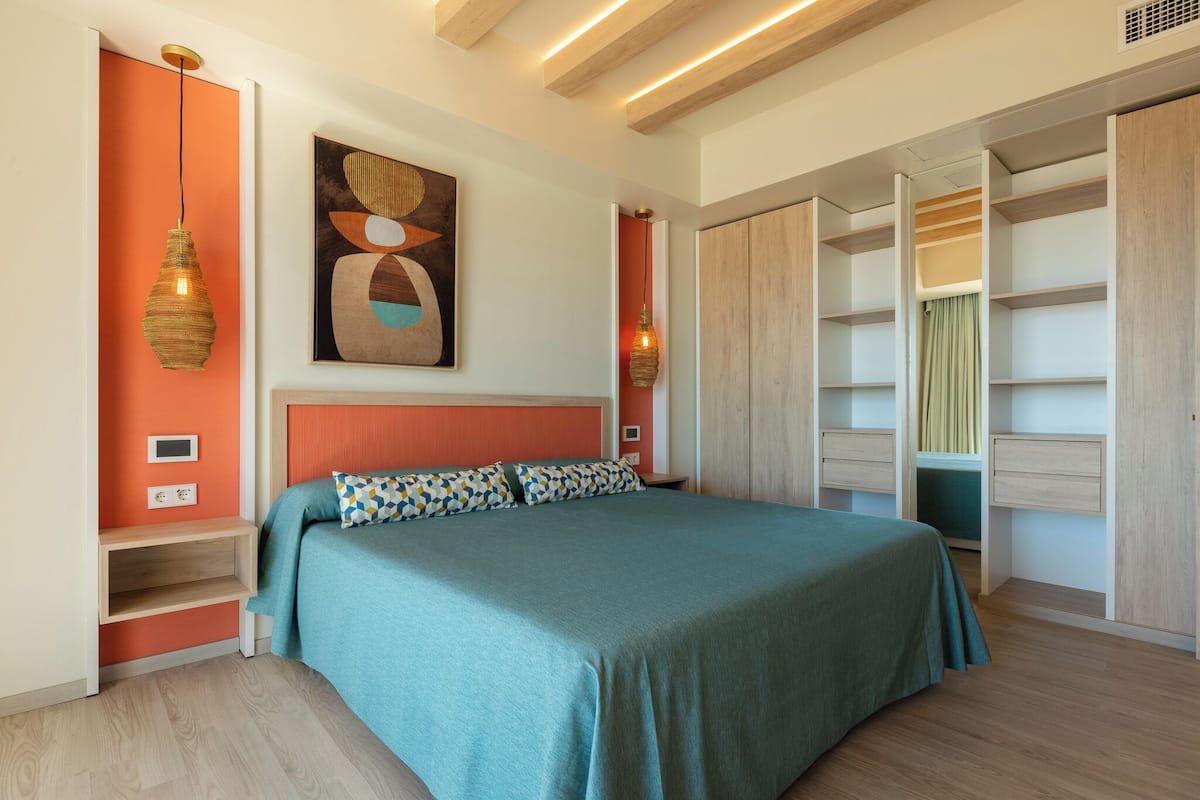 Une chambre à coucher avec un lit, une armoire et un tableau accroché au mur.