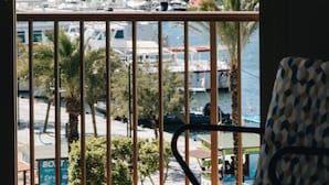A view from a balcony overlooking a marina with boats, palm trees, and a distant hilly landscape. - The White Apartments by Ibiza Feeling - Adults Only (Sant Antoni de Portmany)